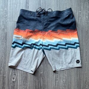 O'Neill Black and Orange Wave Pattern Board Shorts